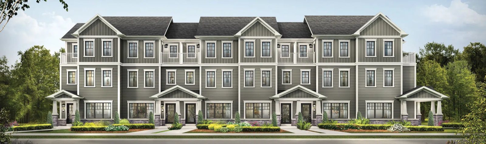 Row of new detached homes with front porches and garages on a sunny street