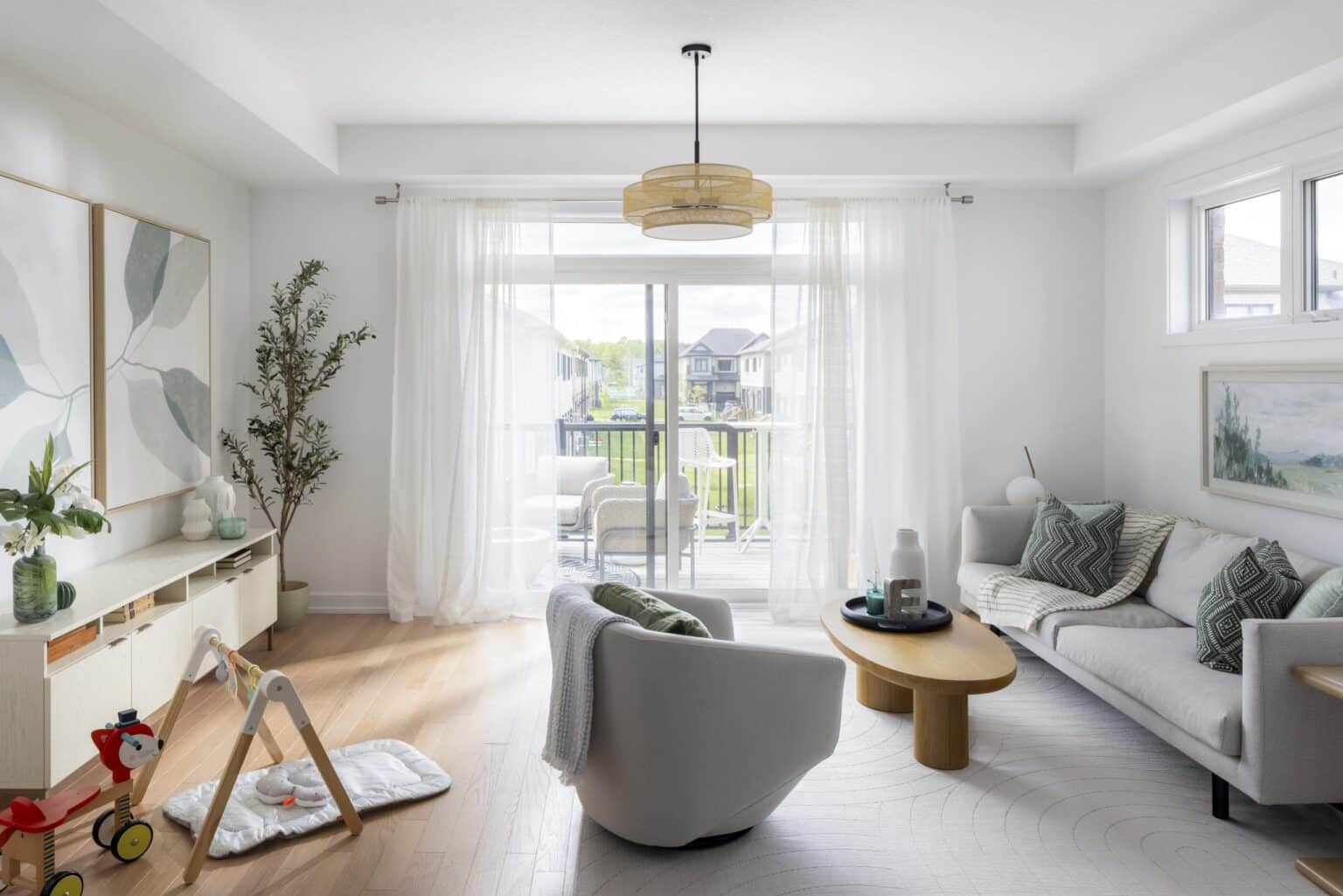 Bright living room with large windows, sofa and swivel chair